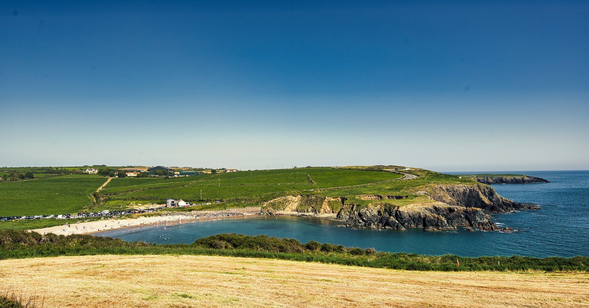 The sandy beach and headlands of Kilmurrin Cove on a clear summer day